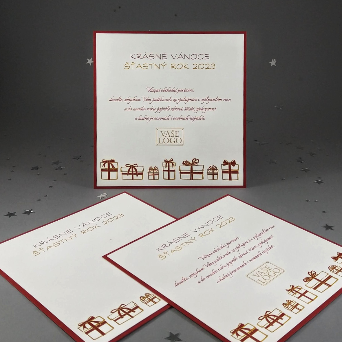 Novoroční–vánoční přání, dvouvrstvá karta s motivem vánočních dárků, čtvercový formát.