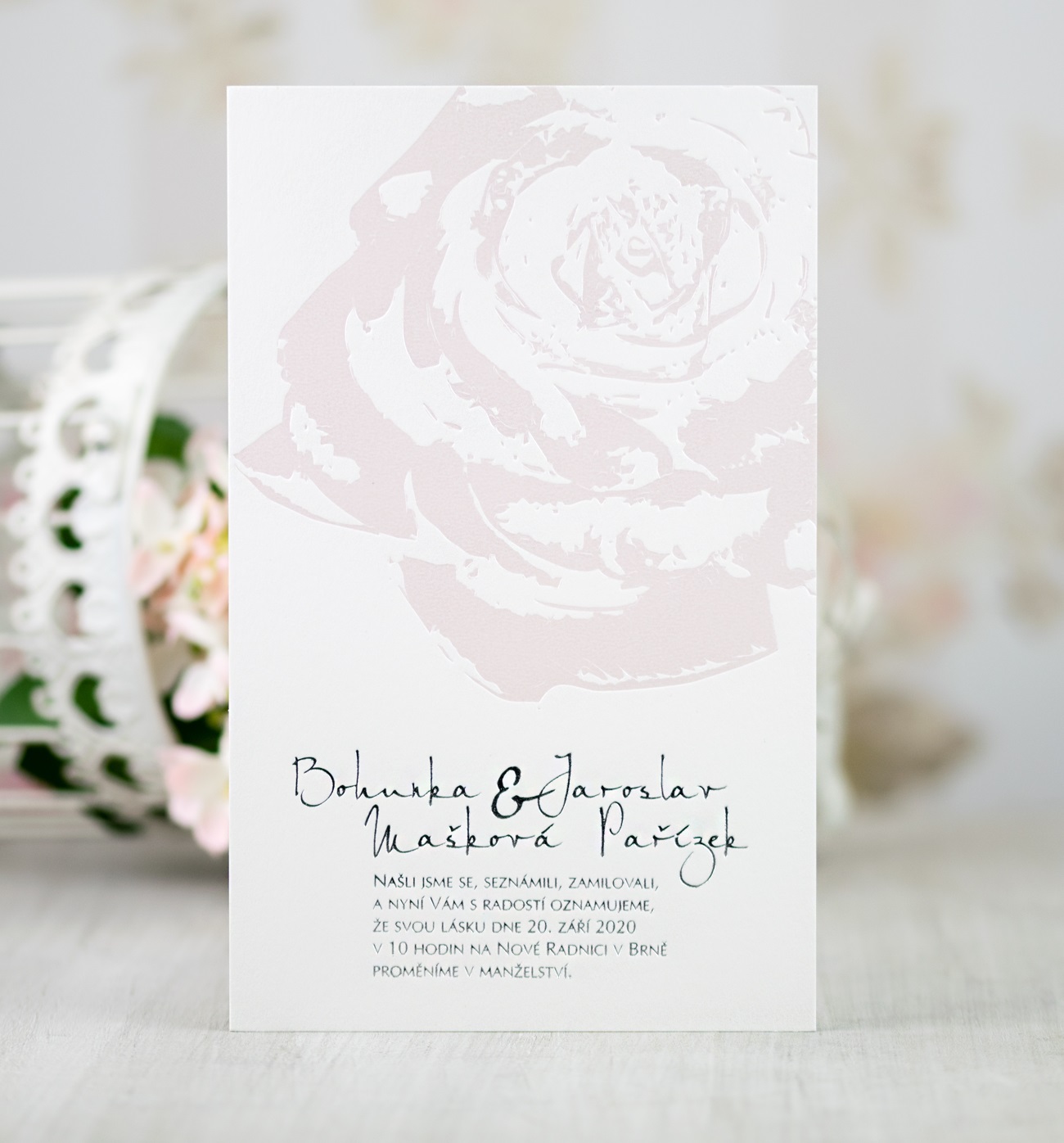 Svatební oznámení –  karta s motivem květu růže na bílém mírně strukturovaném grafickém papíru.