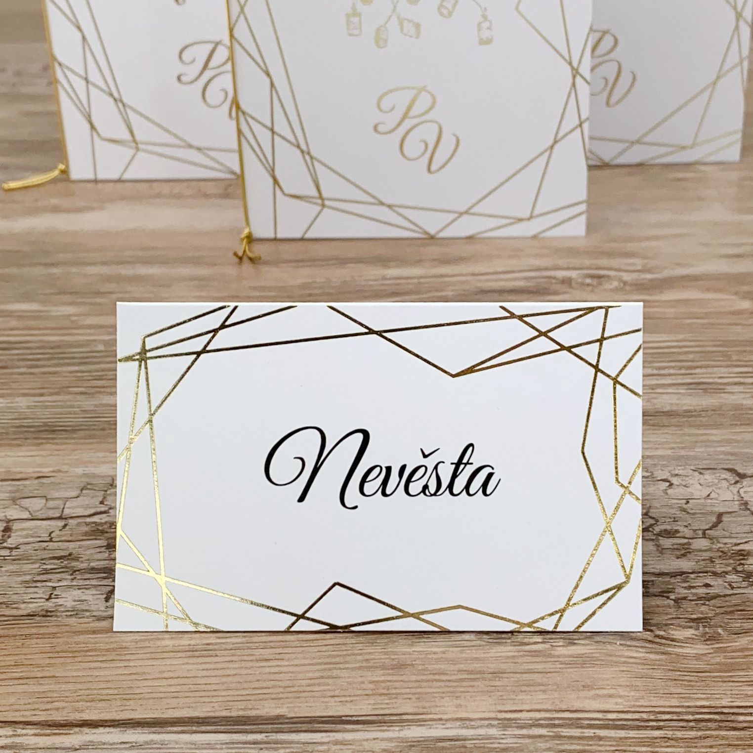 Jmenovka – z bílého, hladkého papíru, motiv rámečku je vytvořen zlatou ražbou, 105 × 65 mm, jednostranná