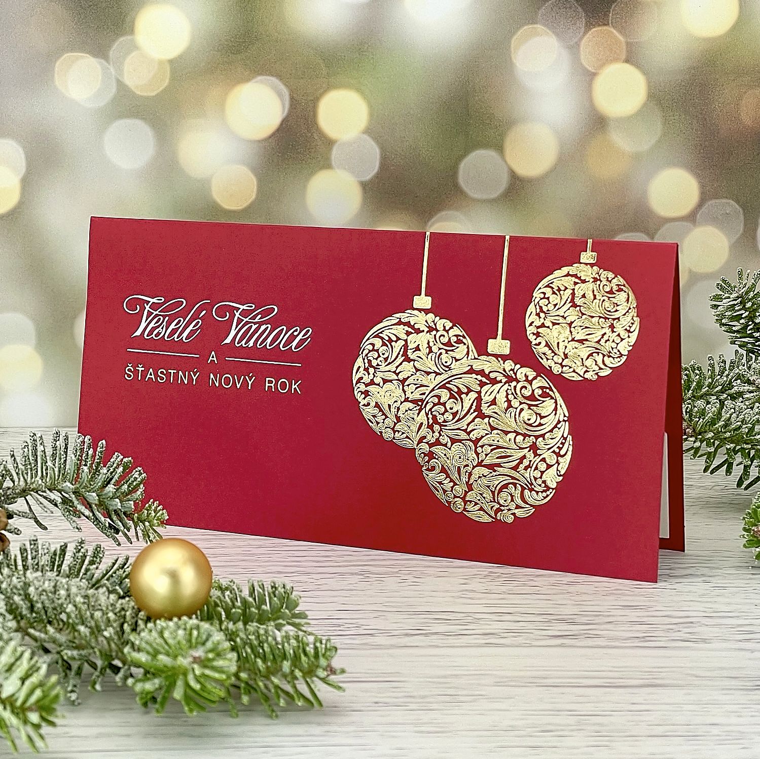 Novoroční–vánoční přání s reliéfní ražbou trojice zlatých baněk; otevírací, formát 200 × 100 mm.