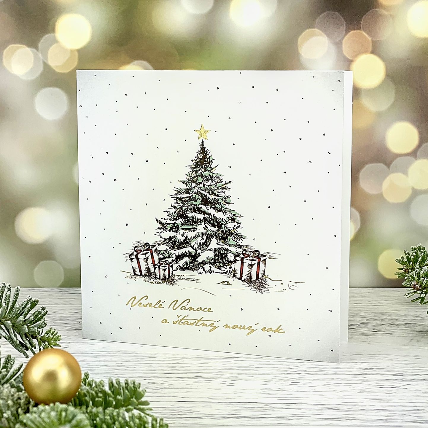 Novoroční–vánoční přání s kresbou vánočního stromku s dárky, bílý grafický papír, otevírací, čtvercový formát 135 × 135 mm.