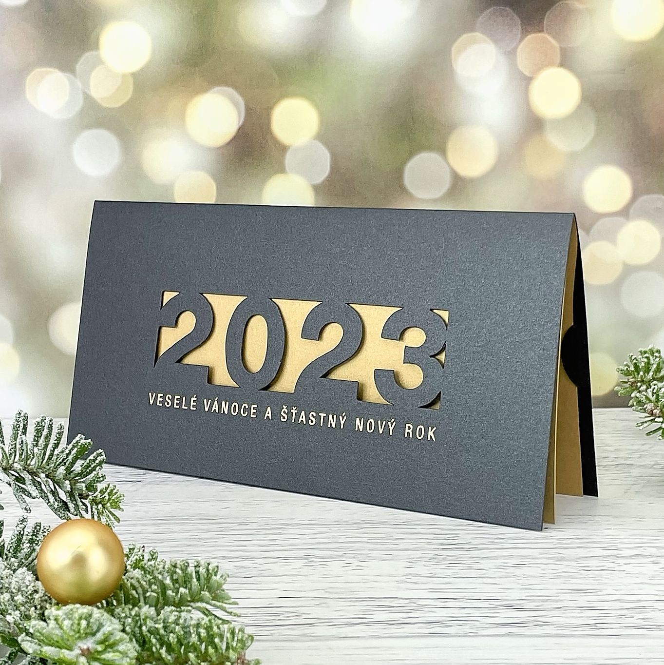 Novoroční–vánoční přání z metalického papíru s motivem laserovanéholetopočtu, otevírací, DL formát 200 × 100 mm (v zavřeném stavu)..