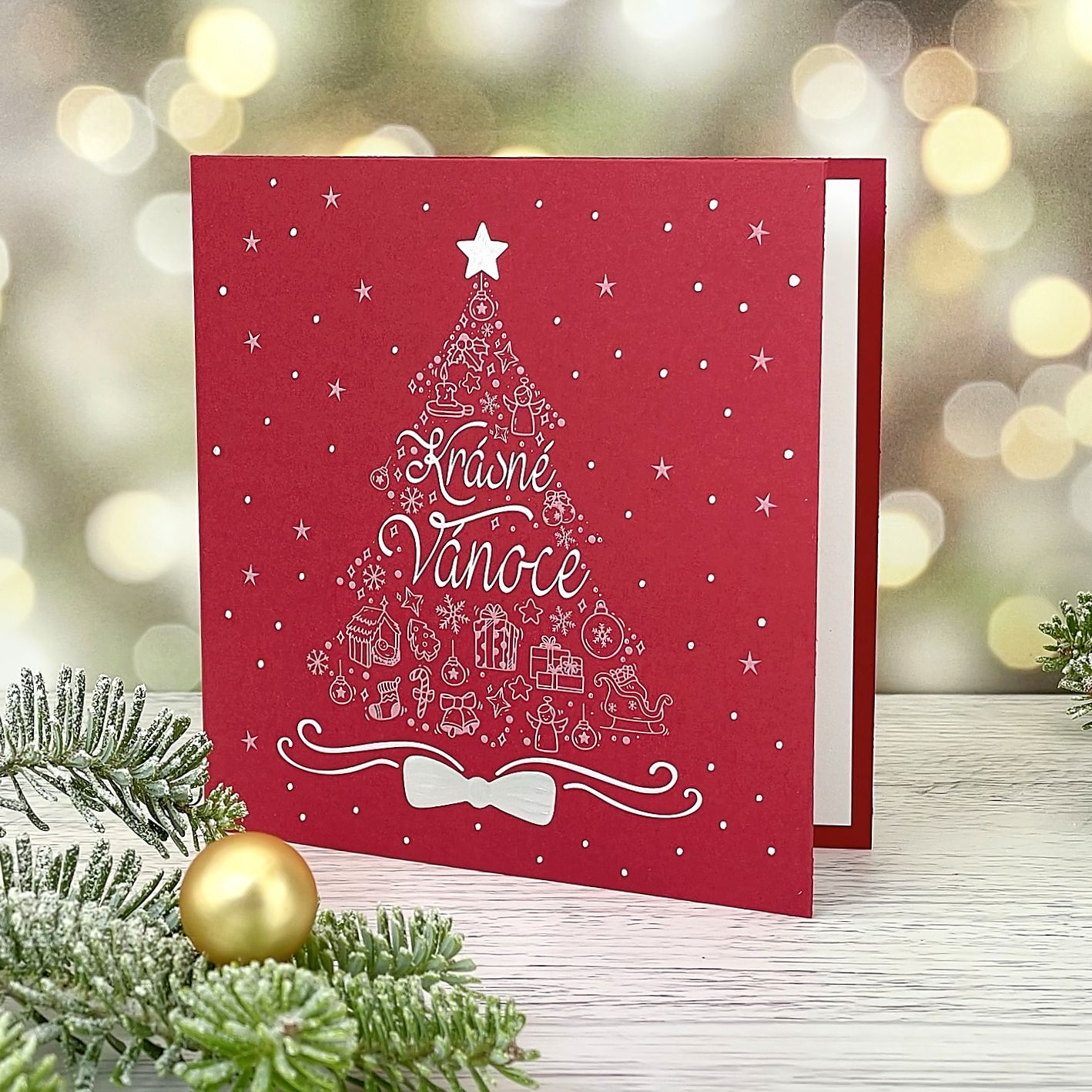 Novoroční–vánoční přání z vesele červeného grafického papíru s motivem stříbrno bílého vánočního stromu, otevírací, formát 135 × 135 mm.
