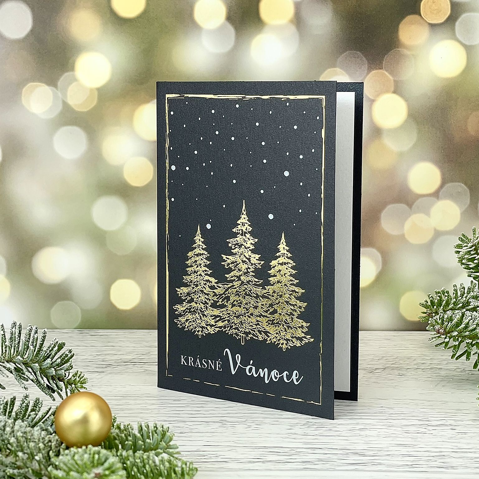Novoroční–vánoční přání z tmavě šedého perleťového papíru s motivem trojice zlatých stromů, otevírací, formát 100 × 150 mm.