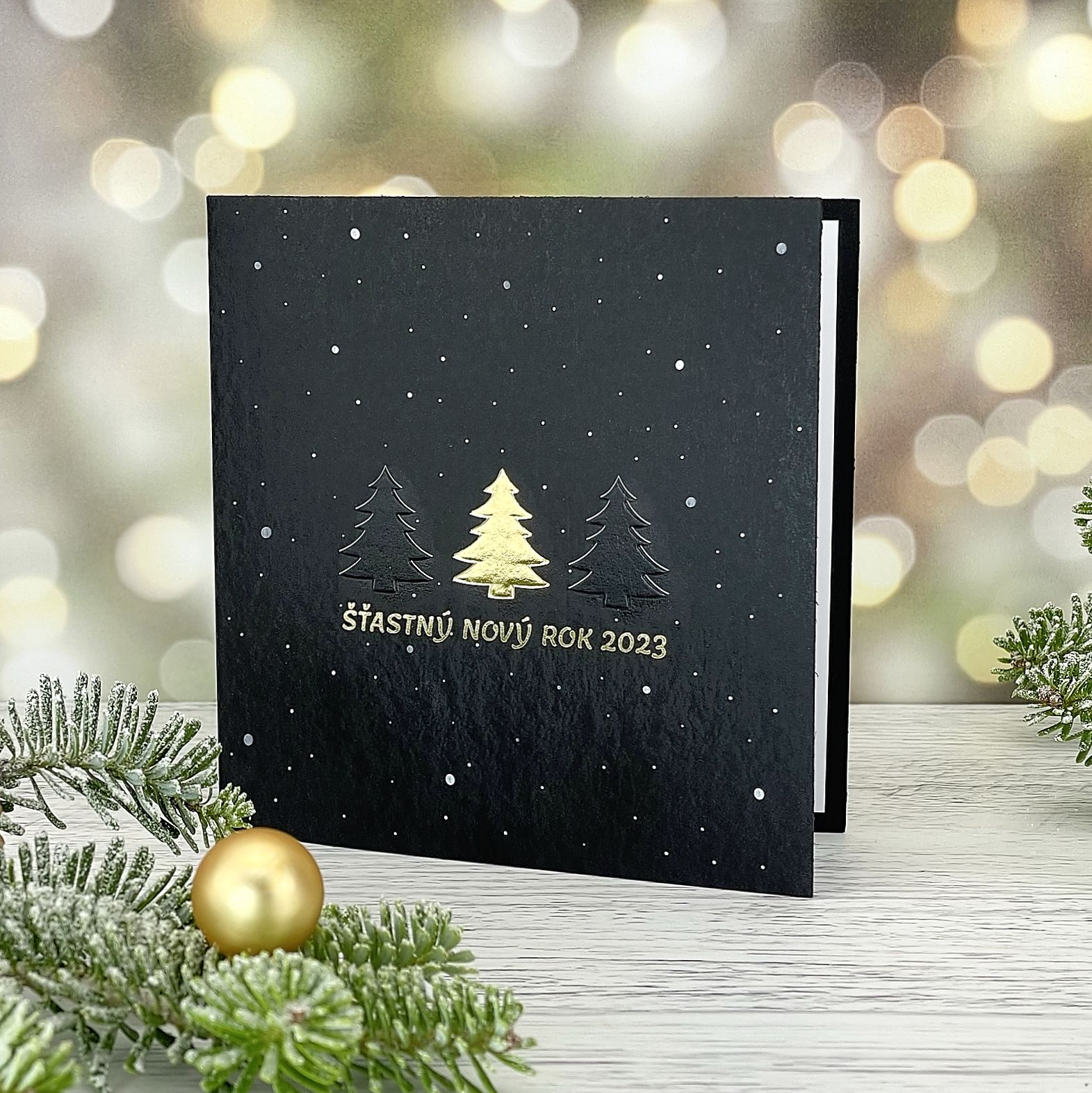 Novoroční–vánoční přání s minimalistickým vánočním motivem, černý grafický papír, otevírací, formát 135 × 135 mm.