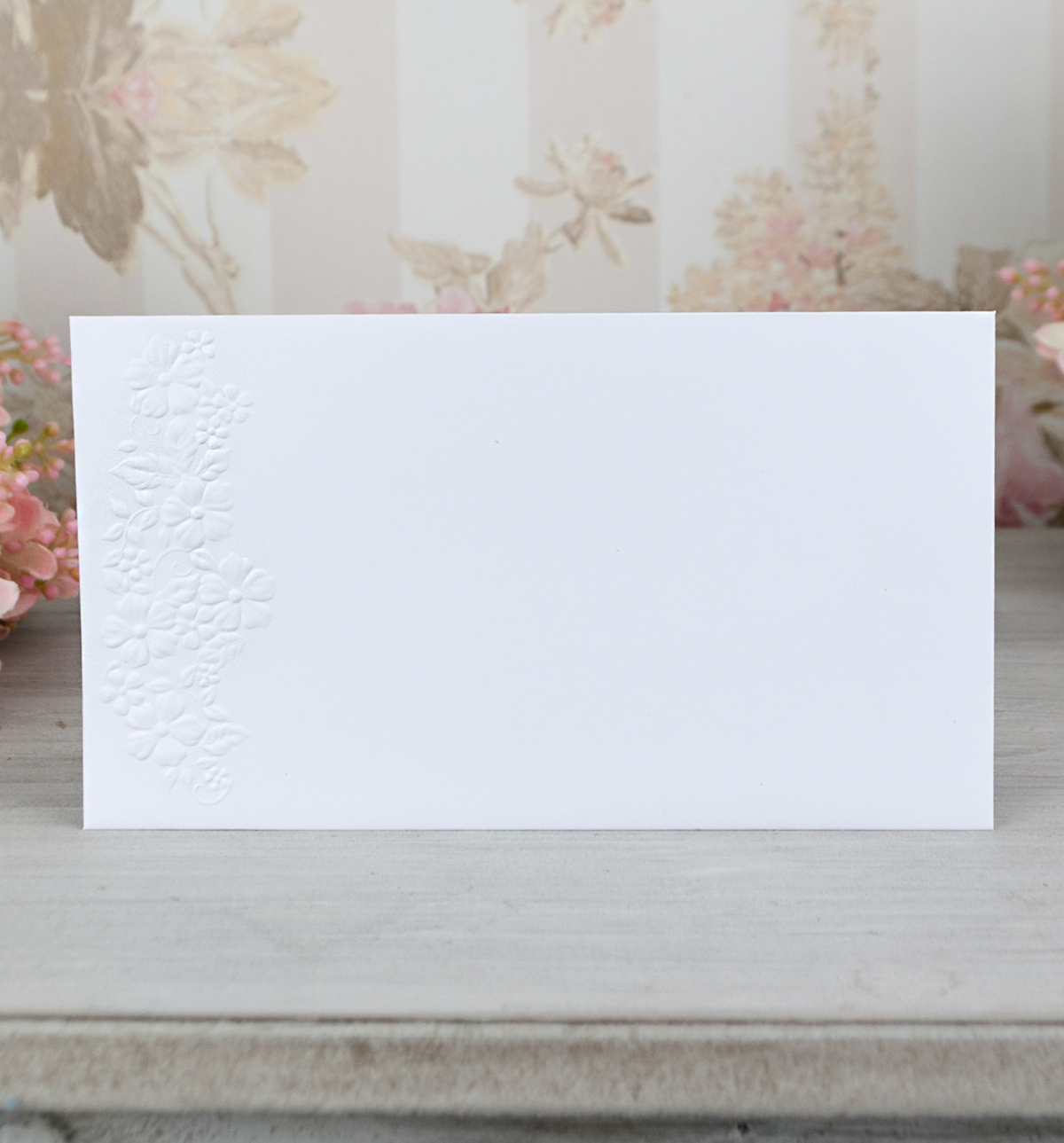 Obálka – z bílého, hladkého grafického papíru se slepotiskovým motivem, formát: 167 × 94 mm