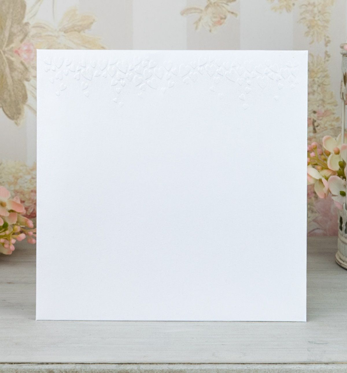 Obálka – z bílého perleťového papíru se slepotiskovými srdíčky, formát: 141 × 141 mm