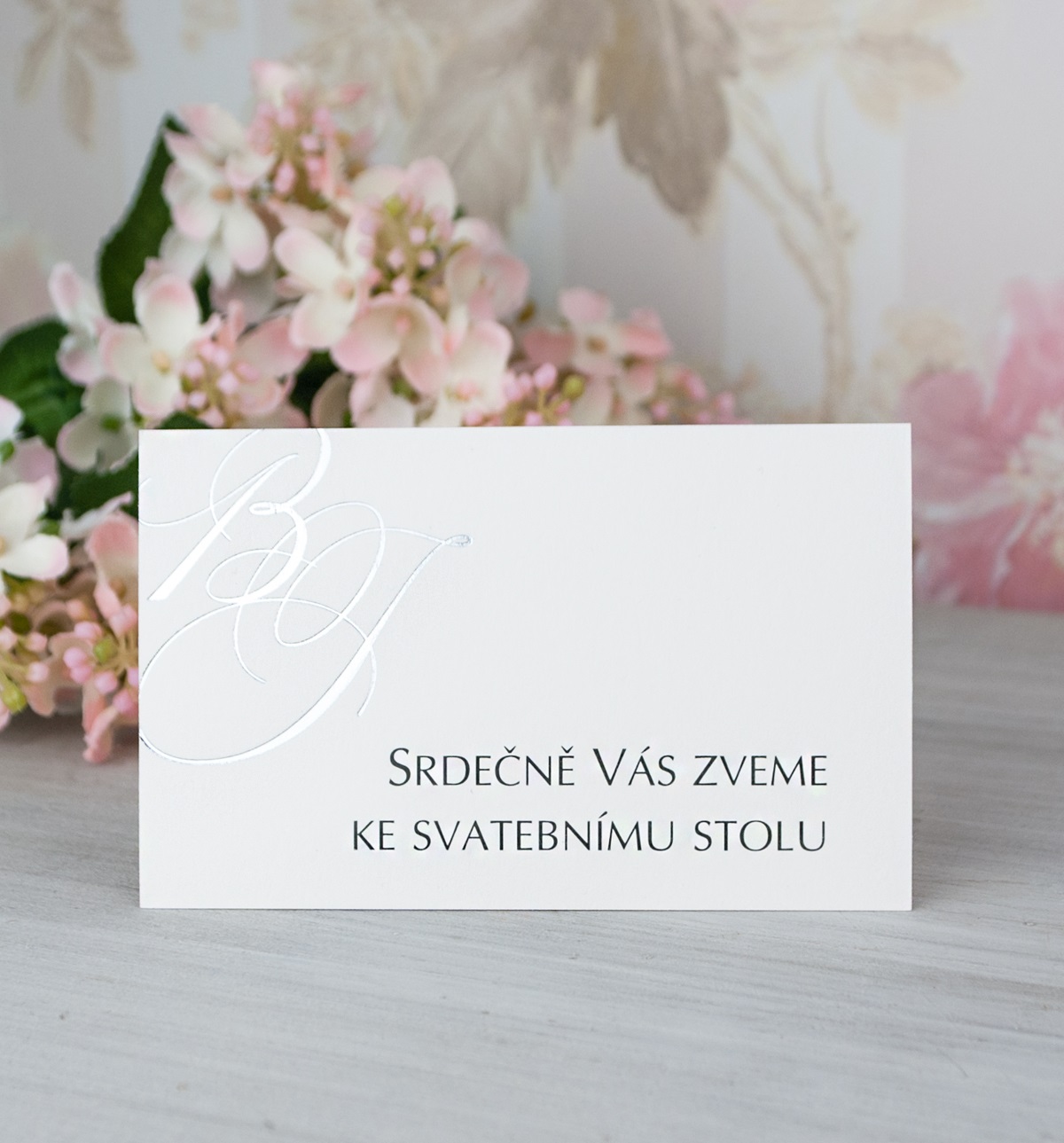 Pozvánka, informační karta – z bílého mírně strukturovaného papíru s monogramy novomanželů, 80 × 50 mm, jednostranná.