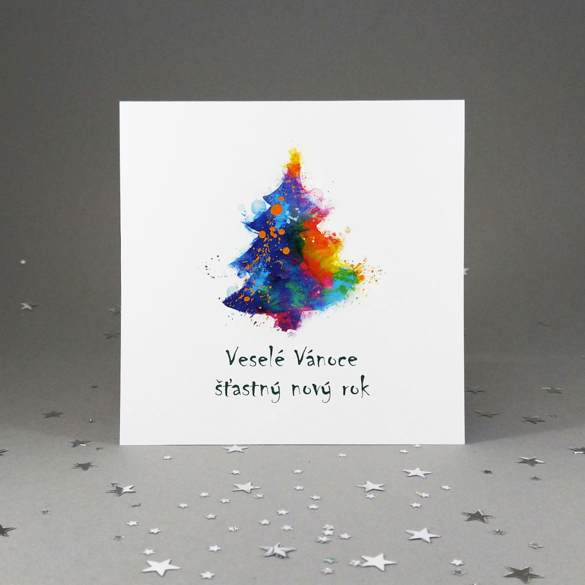 Novoroční-vánoční přání s motivem barevného vánočního stromku. Otevírací, čtvercový formát 140 × 140 mm, digitální tisk, jasně bílý hlazený papír.