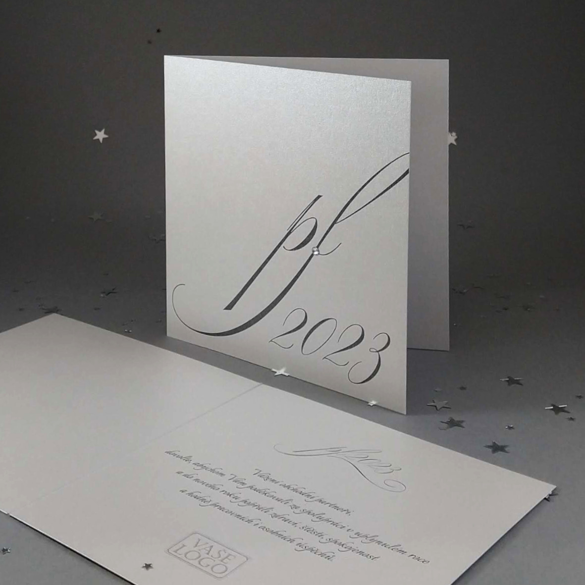 Novoroční–vánoční přání s elegantním motivem pf2023 s ledovým krystalem. Otevírací, formát 140 × 140 mm, digitální tisk, stříbrný perleťový papír.