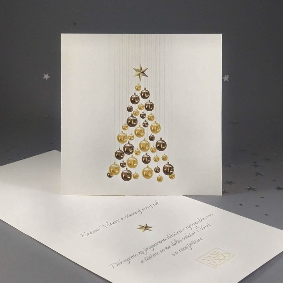 Novoroční–vánoční přání s motivem vánočního stromečku z baněk šedohnědé a krémové barvy. Otevírací, čtvercový formát 140 × 140 mm, digitální tisk, světle zlatý perleťový.