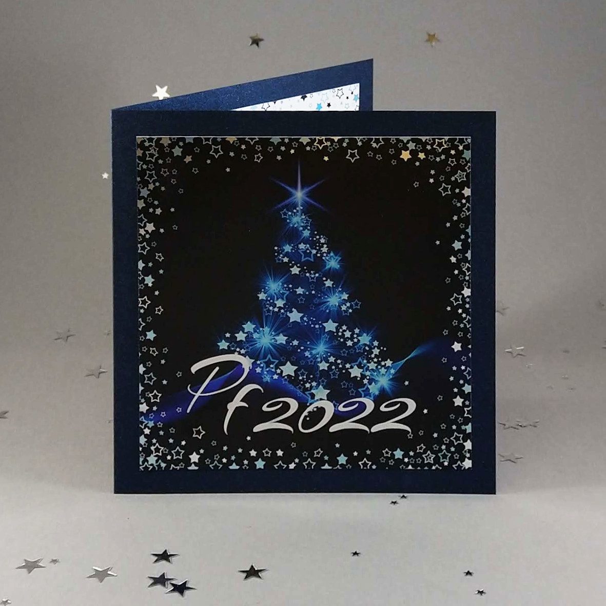 Novoroční–vánoční přání s motivem vánočního stromu v metalicky modrých tónech. otevírací, čtvercový formát 150 × 150 mm, tmavě modrý perleťový papír.