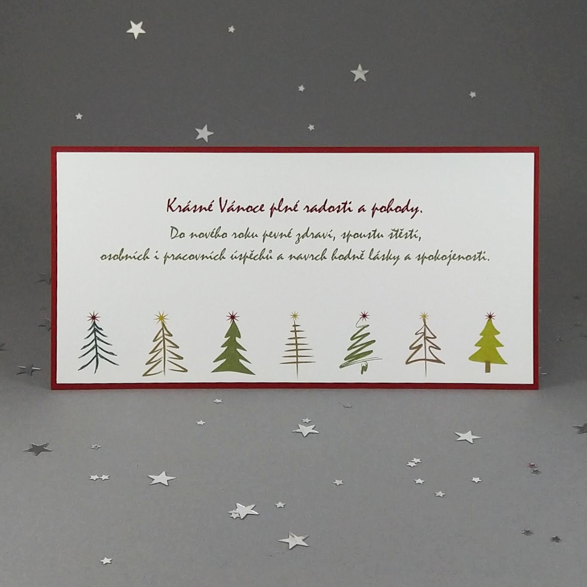 Novoroční–vánoční přání v přírodním stylu s motivem řady stromků. Dvouvrstvá karta, formát 200 × 100 mm, digitální tisk.