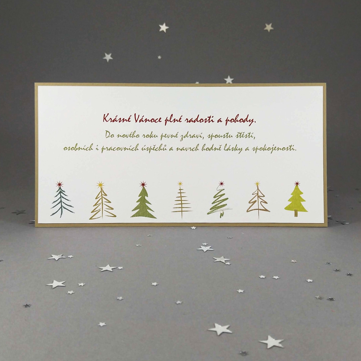 Novoroční–vánoční přání v přírodním stylu s motivem řady stromků. Dvouvrstvá karta, formát 200 × 100 mm, digitální tisk.