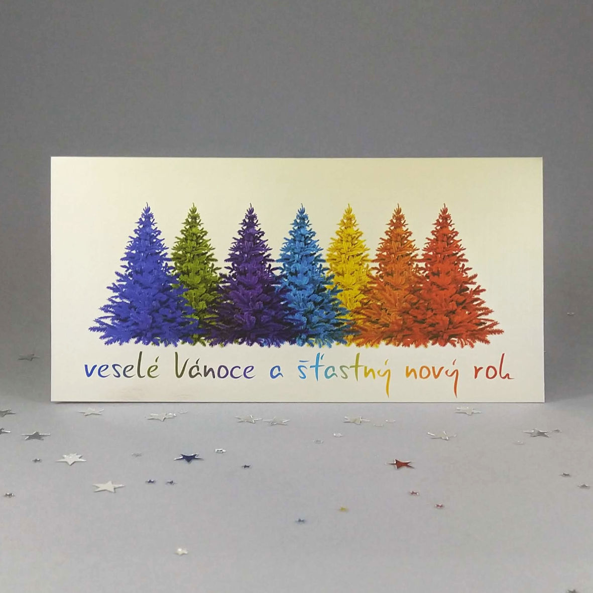 Novoroční–vánoční přání s motivem stromků v barvě duhy, otevírací, DL formát 200 × 100 mm, digitální tisk, stříbrozlatý metalický papír s vysokým leskem.