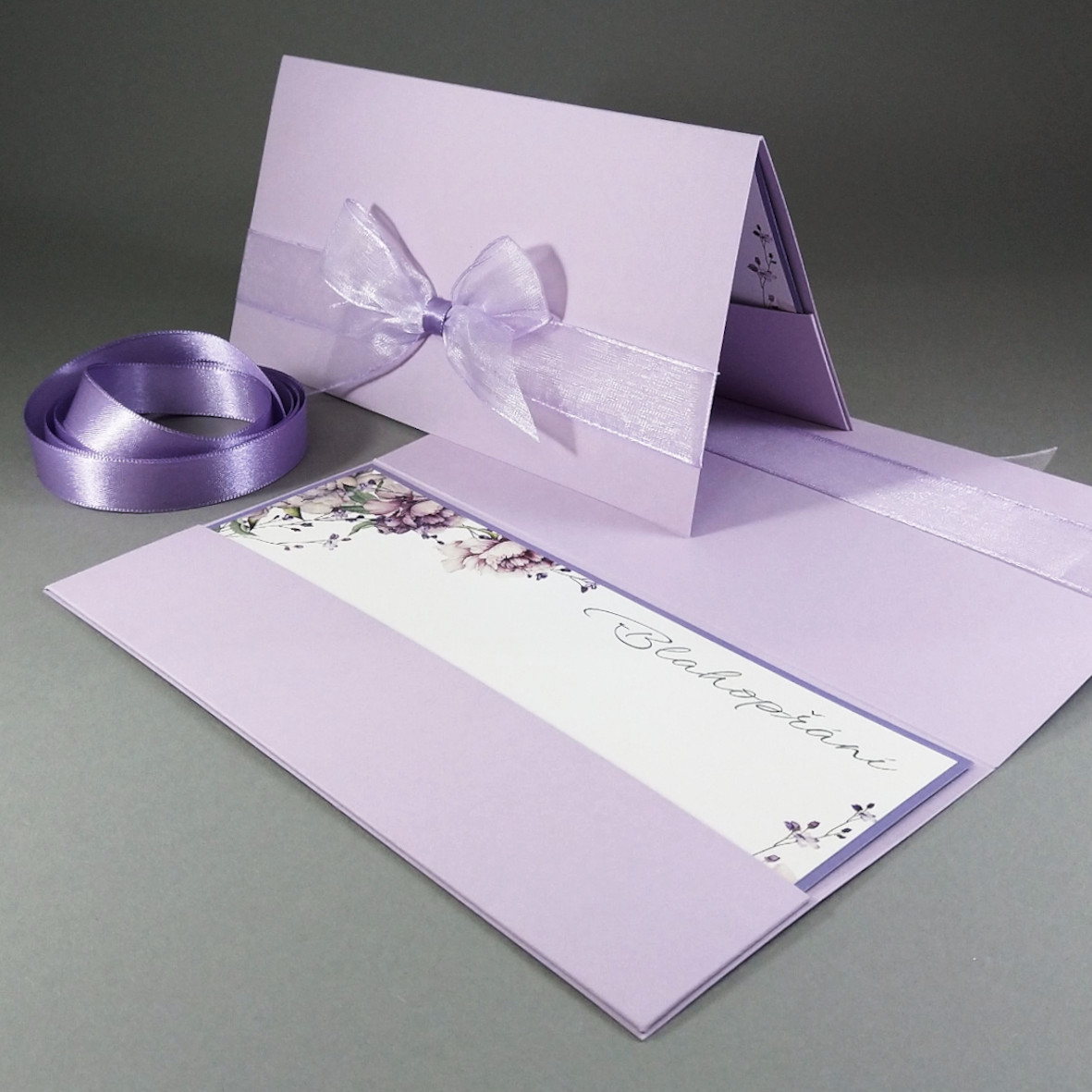 Blahopřání – dvouvrstvá karta vložená do dárkové obálky, převládající barva fialová.