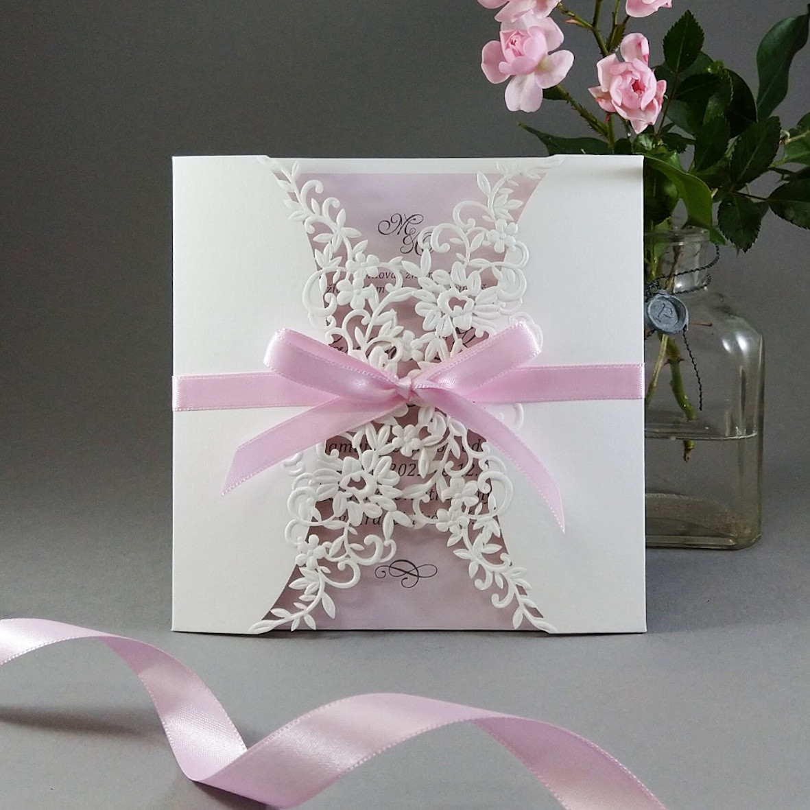 Svatební oznámení – čtvercové s krajkovým přebalem s růžovou vnitřní kartou a atlasovou stuhou.